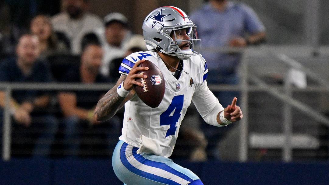 Dallas Cowboys quarterback Dak Prescott runs with the ball during the game between the Dallas Cowboys and the Arizona Cardinals at AT&T Stadium.