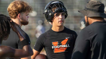 Lakeland Football Coach Marvin Frazier talks with Lakeland High School quarterbacks Zander Smith (left) and Chad Williams during their first day of practice at Bryant Stadium in Lakeland Florida