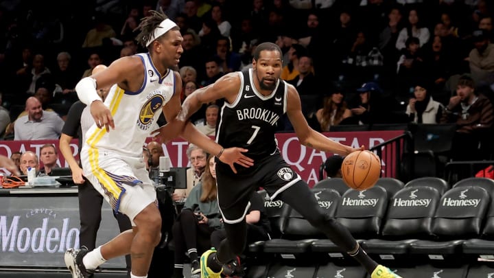 Dec 21, 2022; Brooklyn, New York, USA; Brooklyn Nets forward Kevin Durant (7) drives around Golden State Warriors center Kevon Looney (5) during the third quarter at Barclays Center. Mandatory Credit: Brad Penner-USA TODAY Sports