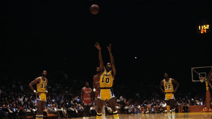 Mar 7, 1980; Inglewood, CA, USA; FILE PHOTO; Los Angeles Lakers center Kareem Abdul-Jabbar (33) and guard Magic Johnson (32) look on as point guard Norm Nixon (10) shoots a free throw against the Chicago Bulls at The Forum. Mandatory Credit: David Boss-USA TODAY NETWORK