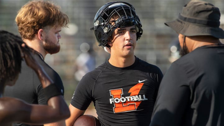 Lakeland Football Coach Marvin Frazier talks with Lakeland High School quarterbacks Zander Smith (left) and Chad Williams during their first day of practice at Bryant Stadium in Lakeland Florida