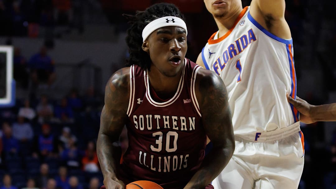 Nov 22, 2024; Gainesville, Florida, USA; Southern Illinois Salukis guard Kennard Davis Jr. (30) drives to the basket past Florida Gators guard Walter Clayton Jr. (1) and Florida Gators center Rueben Chinyelu (9) during the first half at Exactech Arena at the Stephen C. O'Connell Center. Mandatory Credit: Matt Pendleton-Imagn Images