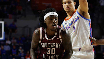 Nov 22, 2024; Gainesville, Florida, USA; Southern Illinois Salukis guard Kennard Davis Jr. (30) drives to the basket past Florida Gators guard Walter Clayton Jr. (1) and Florida Gators center Rueben Chinyelu (9) during the first half at Exactech Arena at the Stephen C. O'Connell Center. Mandatory Credit: Matt Pendleton-Imagn Images