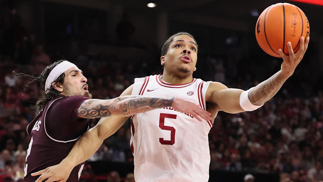 Feb 25, 2026; Fayetteville, Arkansas, USA; Arkansas Razorbacks guard Darius Acuff Jr. (5) drives to the basket as Texas A&M Aggies guard Pop Isaacs (2) defends during the second half at Bud Walton Arena. Arkansas won 99-84. Mandatory Credit: Nelson Chenault-Imagn Images