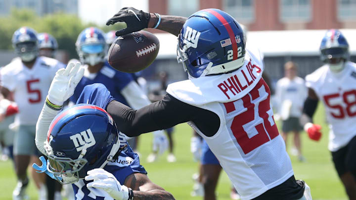 Jul 24, 2025; East Rutherford, NJ, USA; New York Giants cornerback Dru Phillips (22) intercepts a ball intended for wide receiver Wan'Dale Robinson (17)  during training camp at Quest Diagnostics Training Center. Mandatory Credit: Vincent Carchietta-Imagn Images