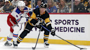 Oct 9, 2024; Pittsburgh, Pennsylvania, USA;  Pittsburgh Penguins right wing Rutger McGroarty (2) moves the puck against New York Rangers defenseman Braden Schneider (4) during the first period at PPG Paints Arena. Mandatory Credit: Charles LeClaire-Imagn Images