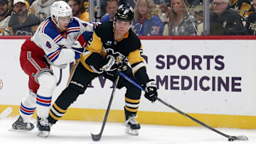 Oct 9, 2024; Pittsburgh, Pennsylvania, USA;  Pittsburgh Penguins right wing Rutger McGroarty (2) moves the puck against New York Rangers defenseman Braden Schneider (4) during the first period at PPG Paints Arena. Mandatory Credit: Charles LeClaire-Imagn Images