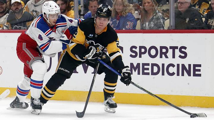 Oct 9, 2024; Pittsburgh, Pennsylvania, USA;  Pittsburgh Penguins right wing Rutger McGroarty (2) moves the puck against New York Rangers defenseman Braden Schneider (4) during the first period at PPG Paints Arena. Mandatory Credit: Charles LeClaire-Imagn Images