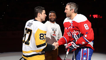 Pittsburgh Penguins center Sidney Crosby (87) shakes hands with Washington Capitals left wing Alex Ovechkin (8) after participating in a ceremonial puck drop with former Capital Joel Ward (M) prior to Black History Game at Capital One Arena.