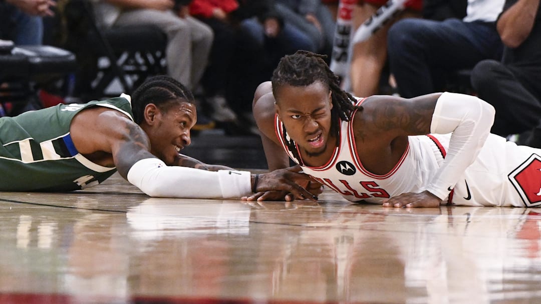 Oct 12, 2025; Chicago, Illinois, USA;  Chicago Bulls guard Ayo Dosunmu (11, right, and Milwaukee Bucks guard/forward Kevin Porter Jr. (7) chase the ball during the first half at the United Center. Mandatory Credit: Matt Marton-Imagn Images