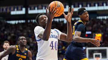 Dec 31, 2024; Lawrence, Kansas, USA; Kansas Jayhawks forward Flory Bidunga (40) grabs a loose ball against West Virginia Mountaineers guard Sencire Harris (10) and center Eduardo Andre (0) during the second half at Allen Fieldhouse. Mandatory Credit: Jay Biggerstaff-Imagn Images