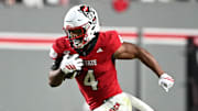 Nov 1, 2025; Raleigh, North Carolina, USA;  North Carolina State Wolfpack running back Jayden Scott (4) runs the ball around Georgia Tech Yellow Jackets linebacker E.J. Lightsey (2) during the first quarter at Carter-Finley Stadium. Mandatory Credit: Zachary Taft-Imagn Images