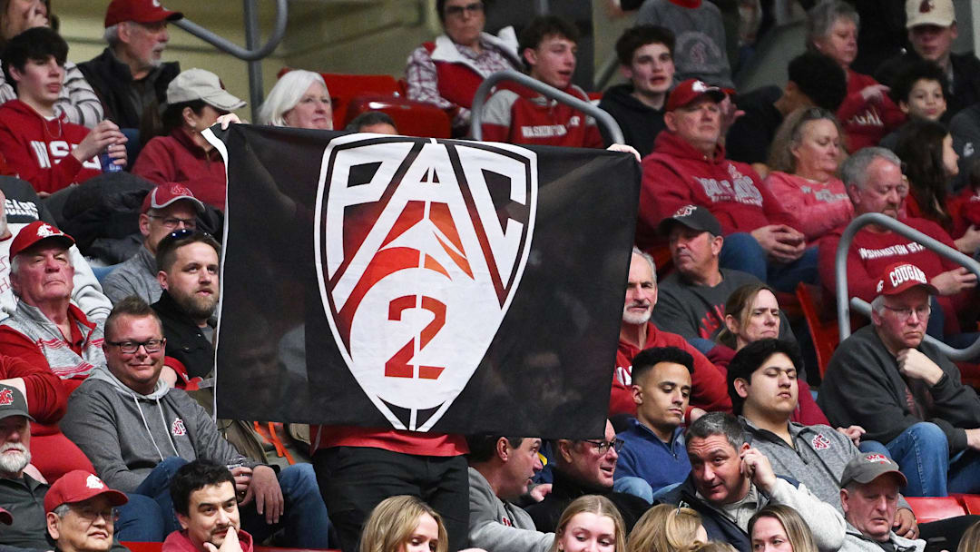 Mar 7, 2024; Pullman, Washington, USA; Washington State Cougars fan holds up a Pac-2 flag during a basketball game against the Washington Huskies in the second half at Friel Court at Beasley Coliseum. Washington Huskies won 74-68. Mandatory Credit: James Snook-Imagn Images Mar 7, 2024; Pullman, Washington, USA; Washington State Cougars fan holds up a Pac-2 flag during a basketball game against the Washington Huskies in the second half at Friel Court at Beasley Coliseum. Washington Huskies won 74-68. Mandatory Credit: James Snook-Imagn Images