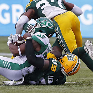 Jun 11, 2023; Edmonton, Alberta, CAN; Edmonton Elks defensive lineman A.C. Leonard (6) tackles Saskatchewan Roughriders running back Frankie Hickson (20) during the first half at Commonwealth Stadium. Mandatory Credit: Perry Nelson-Imagn Images