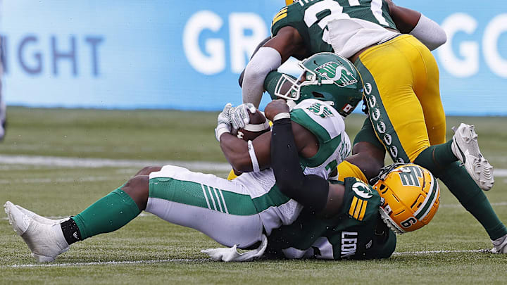 Jun 11, 2023; Edmonton, Alberta, CAN; Edmonton Elks defensive lineman A.C. Leonard (6) tackles Saskatchewan Roughriders running back Frankie Hickson (20) during the first half at Commonwealth Stadium. Mandatory Credit: Perry Nelson-Imagn Images