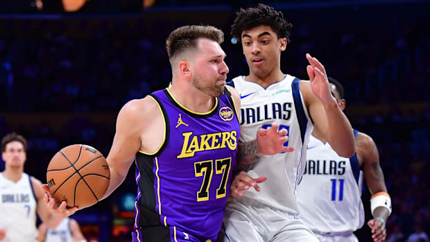 Feb 25, 2025; Los Angeles, California, USA; Lakers' Luka Doncic dribbles past Mavericks' Max Christie.