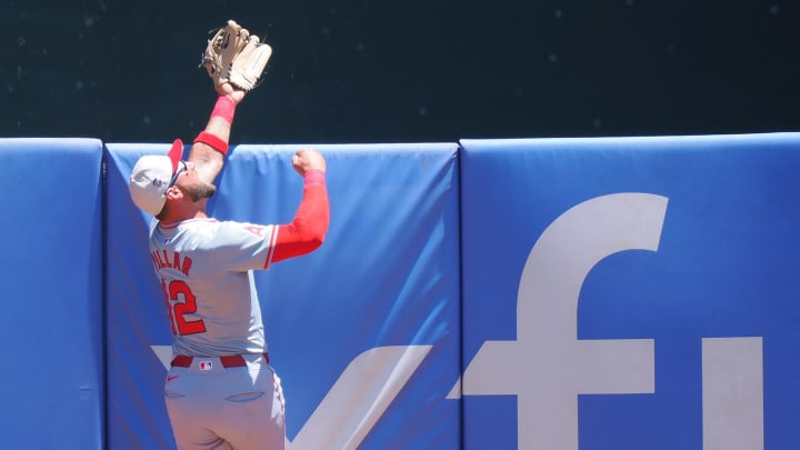 Los Angeles Angels center fielder Kevin Pillar (12) catches the ball above the outfield wall during the first inning against the Oakland Athletics at Oakland-Alameda County Coliseum.