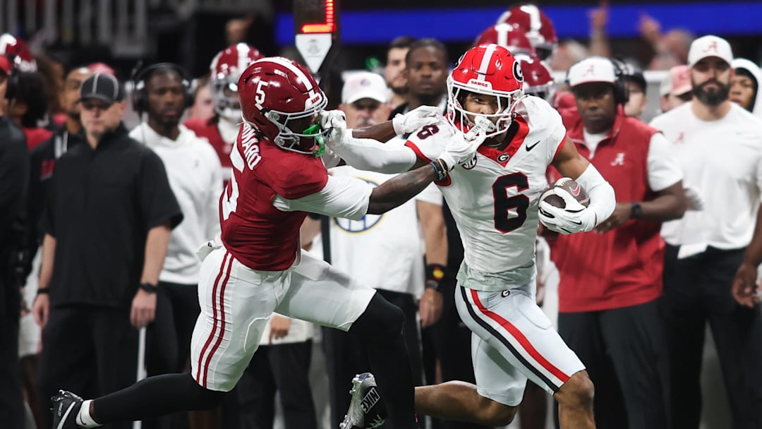 Dec 6, 2025; Atlanta, GA, USA; Georgia Bulldogs defensive back Daylen Everette (6) runs after an interception as Alabama Crimson Tide wide receiver Germie Bernard (5) attempts to tackle during the second quarter during the 2025 SEC Championship game at Mercedes-Benz Stadium. Mandatory Credit: Brett Davis-Imagn Images