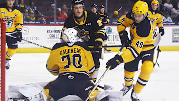 Erie Otters defenseman Matthew Schaefer, right, clears the puck behind teammate Ben Gaudreau against the Sarnia Sting at Erie Insurance Arena in Erie on Oct. 21, 2023.