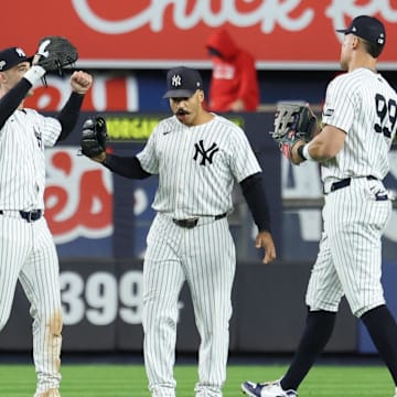 Oct 2, 2025; Bronx, New York, USA; New York Yankee outfielders Cody Bellinger (35), Trent Grisham (12) and Aaron Judge (99) react  following game three of the Wildcard round for the 2025 MLB playoffs against the Boston Red Sox at Yankee Stadium. Mandatory Credit: Vincent Carchietta-Imagn Images