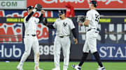 Oct 2, 2025; Bronx, New York, USA; New York Yankee outfielders Cody Bellinger (35), Trent Grisham (12) and Aaron Judge (99) react  following game three of the Wildcard round for the 2025 MLB playoffs against the Boston Red Sox at Yankee Stadium. Mandatory Credit: Vincent Carchietta-Imagn Images