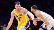Apr 3, 2025; Los Angeles, California, USA; Los Angeles Lakers guard Luka Doncic (77) moves the ball against Golden State Warriors guard Stephen Curry (30) during the first half at Crypto.com Arena. Mandatory Credit: Gary A. Vasquez-Imagn Images