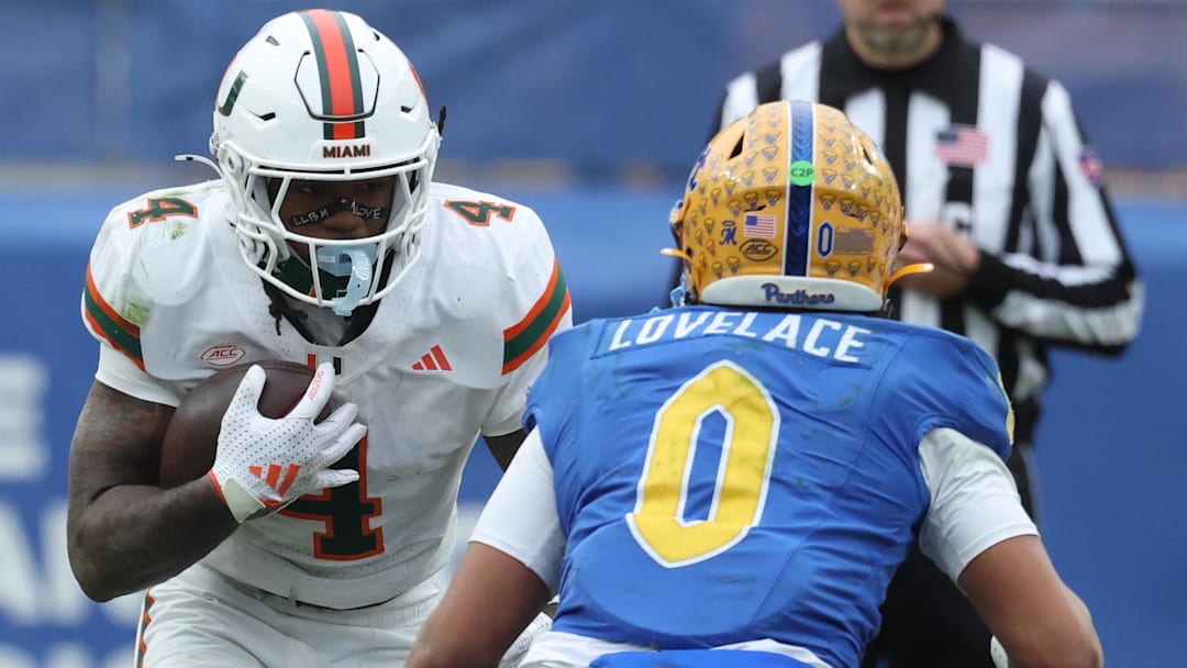 Nov 29, 2025; Pittsburgh, Pennsylvania, USA;  Miami Hurricanes running back Mark Fletcher Jr. (4) runs the ball against Pittsburgh Panthers linebacker Braylan Lovelace (0) during the fourth quarter at Acrisure Stadium. Mandatory Credit: Charles LeClaire-Imagn Images