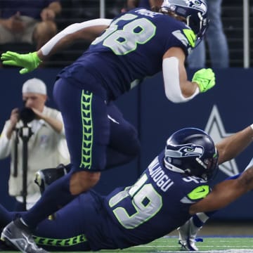 Aug 26, 2022; Arlington, Texas, USA;  Seattle Seahawks linebacker Joshua Onujiogu (49) tackles Dallas Cowboys running back Aaron Shampklin (32) during the first quarter at AT&T Stadium.