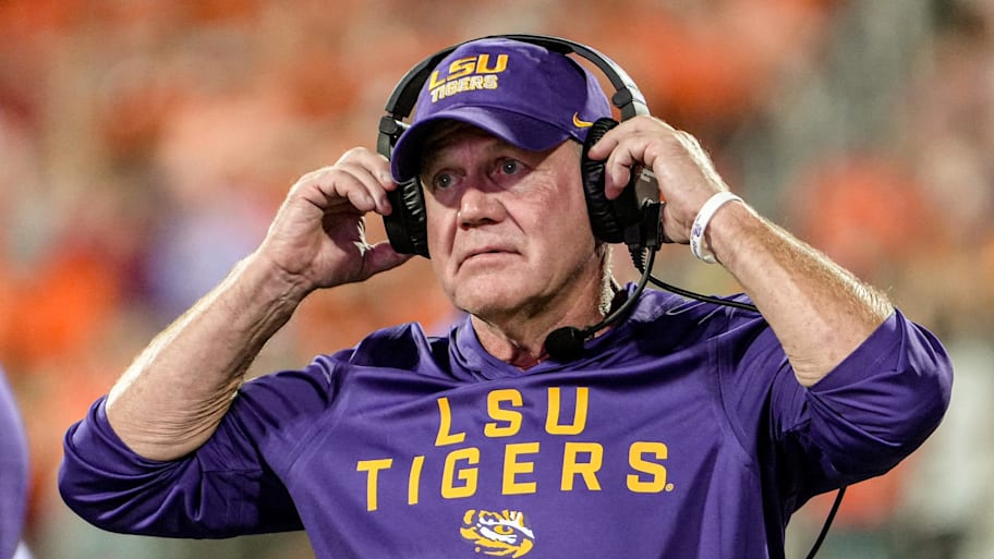 LSU coach Brian Kelly adjusts his headset.