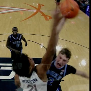 Virginia's Anthony Robinson blocks Duke's Cooper Flagg during a game.