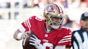 Aug 9, 2025; Santa Clara, California, USA;  San Francisco 49ers quarterback Mac Jones (10) scrambles away from Denver Broncos outside linebacker Nik Bonitto (15) in the first quarter at Levi's Stadium. 