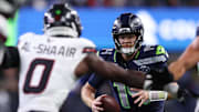 Oct 20, 2025; Seattle, Washington, USA; Seattle Seahawks quarterback Sam Darnold (14) runs with the ball against Houston Texans linebacker Azeez Al-Shaair (0) during the first quarter at Lumen Field. Mandatory Credit: Kevin Ng-Imagn Images