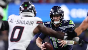 Oct 20, 2025; Seattle, Washington, USA; Seattle Seahawks quarterback Sam Darnold (14) runs with the ball against Houston Texans linebacker Azeez Al-Shaair (0) during the first quarter at Lumen Field. Mandatory Credit: Kevin Ng-Imagn Images