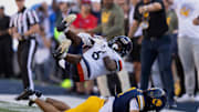 Nov 1, 2025; Berkeley, California, USA; California Golden Bears defensive back Brent Austin (4) upends Virginia Cavaliers wide receiver Cam Ross (6) on a short pass during the fourth quarter at California Memorial Stadium. Mandatory Credit: D. Ross Cameron-Imagn Images