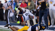 Nov 1, 2025; Berkeley, California, USA; California Golden Bears defensive back Brent Austin (4) upends Virginia Cavaliers wide receiver Cam Ross (6) on a short pass during the fourth quarter at California Memorial Stadium. Mandatory Credit: D. Ross Cameron-Imagn Images