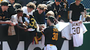 Pittsburgh Pirates pitcher Paul Skenes signs autographs for fans before a game.