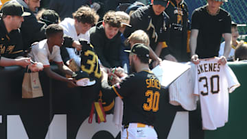 Pittsburgh Pirates pitcher Paul Skenes signs autographs for fans before a game.