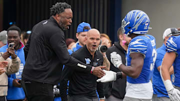 Tim Duncan, Memphis senior deputy athletics director, and Ed Scott, athletic director, celebrate with Memphis' Elijah Herring (31) after the defense sacked Charlotte's Deshawn Purdie (15) for a safety during the game between Charlotte and the University of Memphis at Simmons Bank Liberty Stadium on Saturday, October 26, 2024.