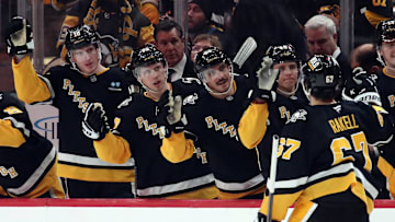 Jan 7, 2025; Pittsburgh, Pennsylvania, USA; Pittsburgh Penguins right wing Rickard Rakell (67) receives congratulations from the bench after scoring his second goal against the Columbus Blue Jackets during the third period at PPG Paints Arena. Mandatory Credit: Charles LeClaire-Imagn Images