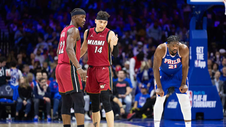 Apr 17, 2024; Philadelphia, Pennsylvania, USA; Miami Heat forward Jimmy Butler (22) and guard Tyler Herro (14) talk as Philadelphia 76ers center Joel Embiid (21) stands behind during the third quarter of a play-in game of the 2024 NBA playoffs at Wells Fargo Center. Mandatory Credit: Bill Streicher-USA TODAY Sports