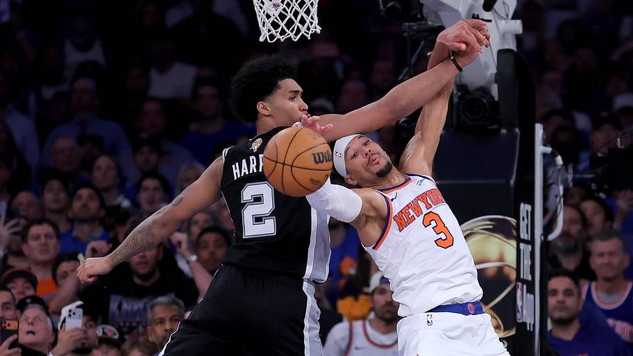San Antonio Spurs guard Dylan Harper fights for a rebound against New York Knicks guard Josh Hart.