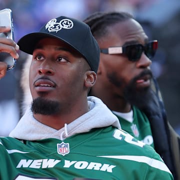 Feb 18, 2024; East Rutherford, New Jersey, USA; New York Jets running back Breece Hall takes pictures with his phone before the first period of a Stadium Series ice hockey game between the New York Islanders and the New York Rangers at MetLife Stadium. 