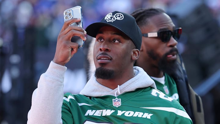 Feb 18, 2024; East Rutherford, New Jersey, USA; New York Jets running back Breece Hall takes pictures with his phone before the first period of a Stadium Series ice hockey game between the New York Islanders and the New York Rangers at MetLife Stadium. 