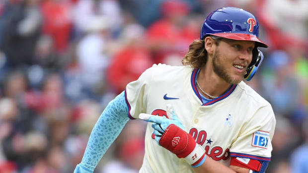 Philadelphia Phillies third baseman Alec Bohm running the bases in a cream-colored uniform and blue sleeve. 
