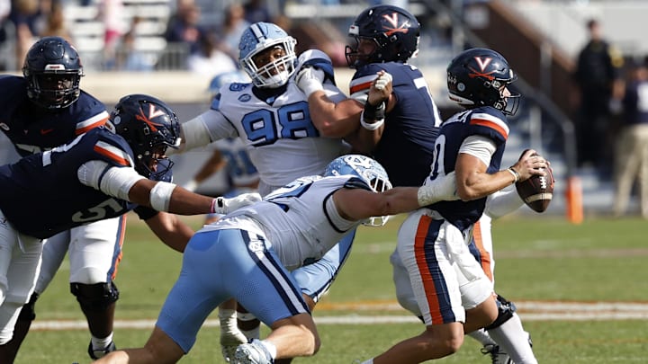Oct 26, 2024; Charlottesville, Virginia, USA; Virginia Cavaliers quarterback Anthony Colandrea (10) is sacked by North Carolina Tar Heels defensive lineman Beau Atkinson (12) during the second half at Scott Stadium. Mandatory Credit: Geoff Burke-Imagn Images