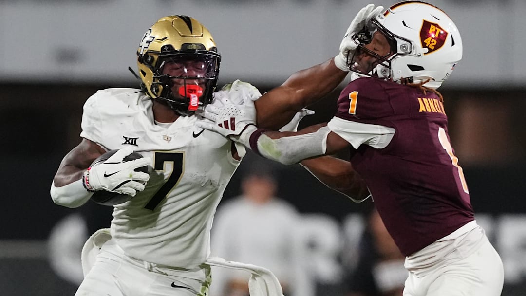 Nov 9, 2024; Tempe, Arizona, USA; UCF Knights running back RJ Harvey (7) delivers a stiff arm to Arizona State Sun Devils defensive back Keith Abney II (1) during the second half at Mountain America Stadium, Home of the ASU Sun Devils. Mandatory Credit: Joe Camporeale-Imagn Images