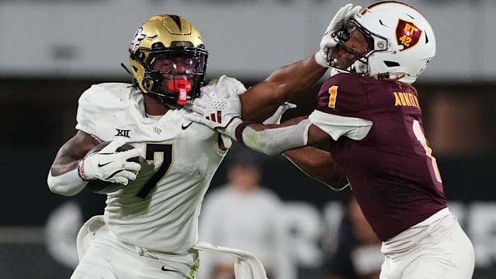 Nov 9, 2024; Tempe, Arizona, USA; UCF Knights running back RJ Harvey (7) delivers a stiff arm to Arizona State Sun Devils defensive back Keith Abney II (1) during the second half at Mountain America Stadium, Home of the ASU Sun Devils. Mandatory Credit: Joe Camporeale-Imagn Images