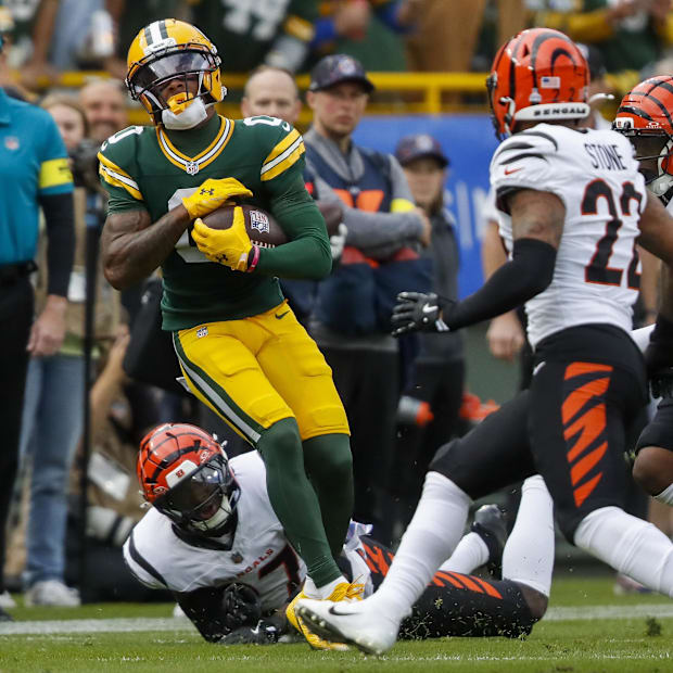 Green Bay Packers wide receiver Matthew Golden (0) spins out of a tackle by Cincinnati Bengals safety Jordan Battle.