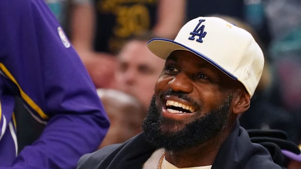 Los Angeles Lakers forward LeBron James, wearing a Los Angeles Dodgers hat, smiles after watching his son, guard Bronny James