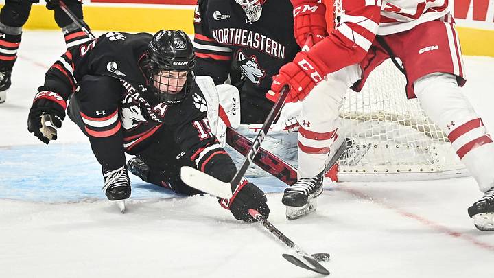Northeastern forward Jack Williams (15) knocks the puck away from Wisconsin forward Carson Bantle (21) during the first period of the championship game of the Kwik Trip Holiday Face-Off on Friday, December 29, 2023, at Fiserv Forum in Milwaukee, Wisconsin.